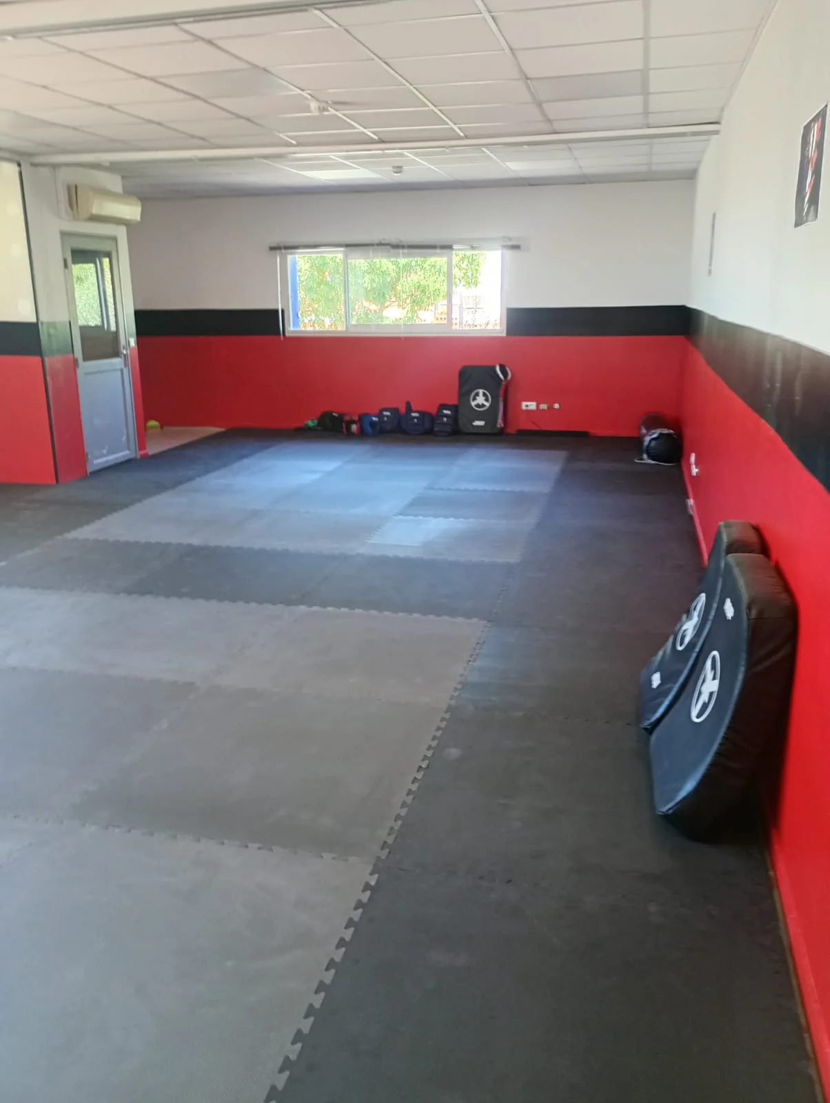 Salle terminée du MK Boxing Club à Congénies, avec tatamis et murs rouges et noirs