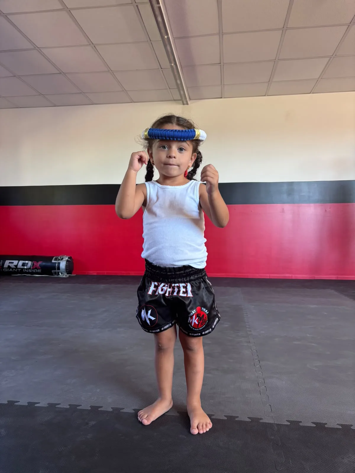 Un jeune enfant pendant un cours de baby boxe dans la salle