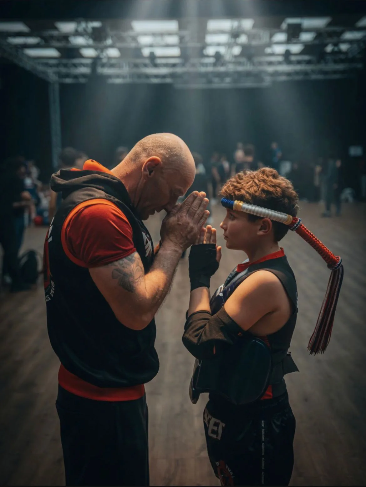 Le coach et un jeune combattant saluent avant un combat